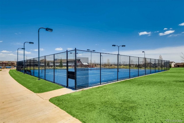 view of sport court featuring a lawn