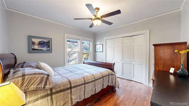 bedroom featuring a ceiling fan, a closet, ornamental molding, and wood finished floors