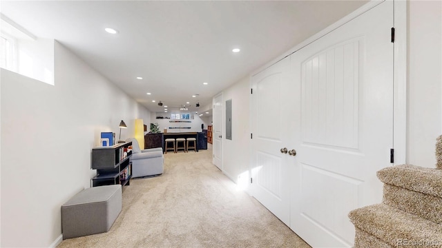 corridor featuring light carpet, electric panel, stairway, and recessed lighting