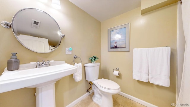 bathroom featuring tile patterned flooring, toilet, a sink, visible vents, and baseboards