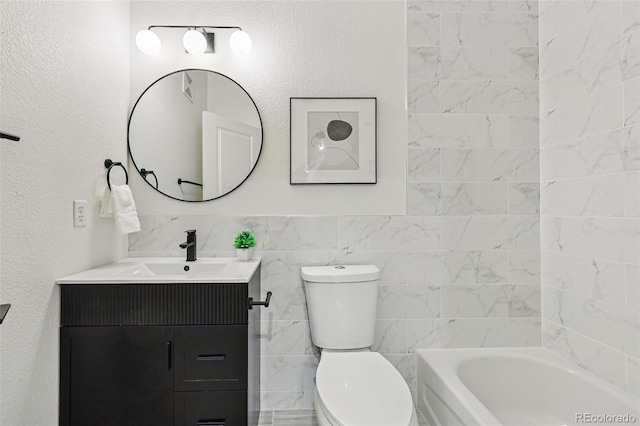 bathroom with tile walls, a bathtub, toilet, and vanity