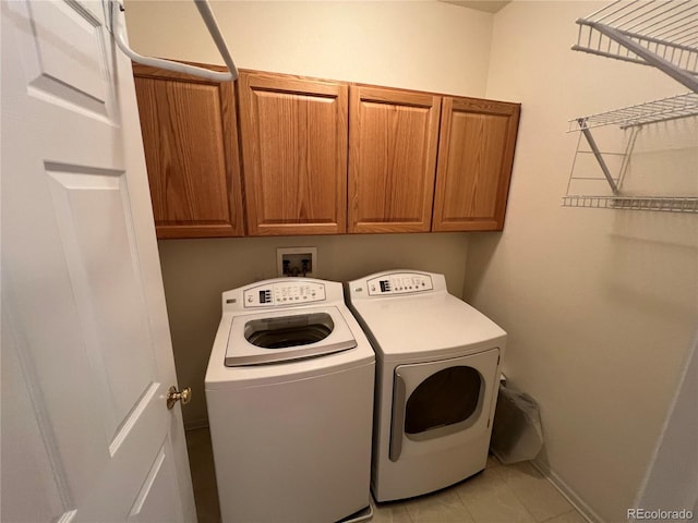 laundry room with washing machine and dryer and cabinets