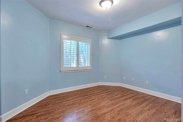 unfurnished room with wood finished floors and baseboards