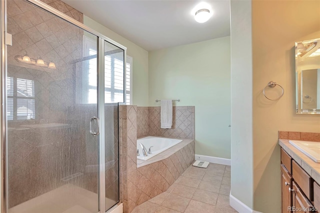 bathroom featuring tile patterned flooring, a garden tub, vanity, a shower stall, and baseboards