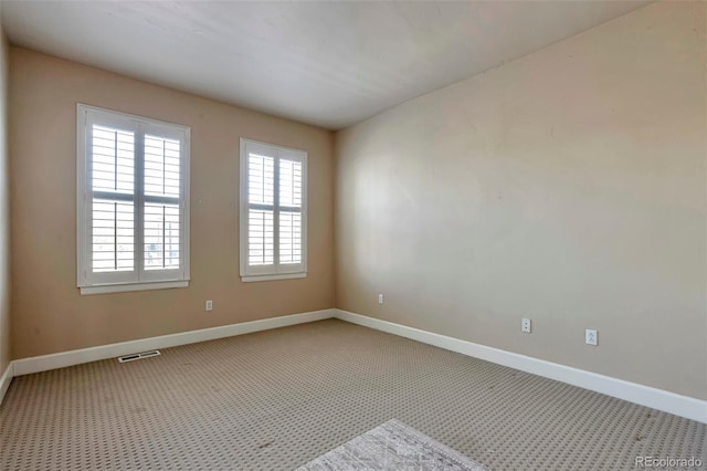 spare room with baseboards and carpet