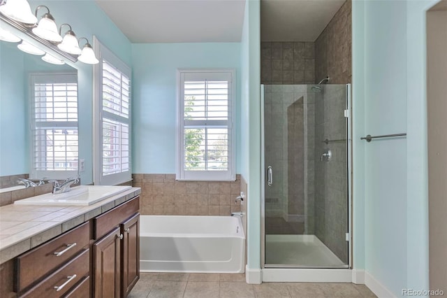 full bathroom with a shower stall, tile patterned flooring, vanity, and a garden tub
