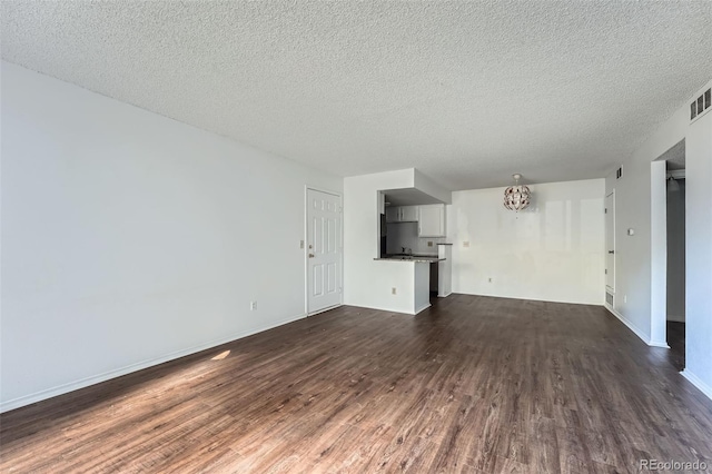 unfurnished living room featuring a textured ceiling and dark hardwood / wood-style floors