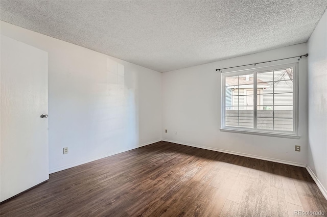 spare room with a textured ceiling and dark wood-type flooring