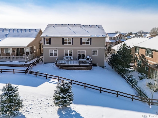 view of snow covered back of property