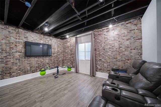 workout area with hardwood / wood-style flooring and brick wall