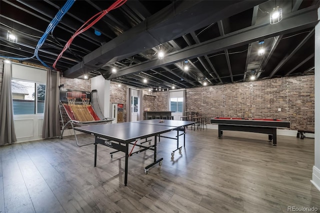 recreation room with hardwood / wood-style flooring, brick wall, and pool table