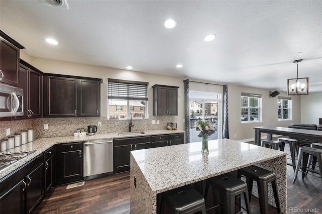 kitchen with a kitchen island, tasteful backsplash, sink, dark hardwood / wood-style flooring, and stainless steel appliances