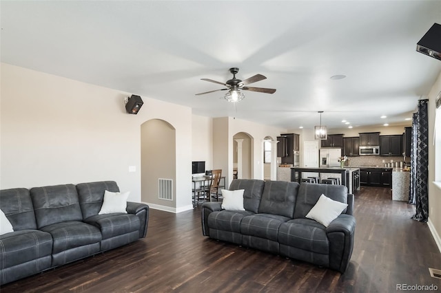 living room with ceiling fan and dark hardwood / wood-style floors