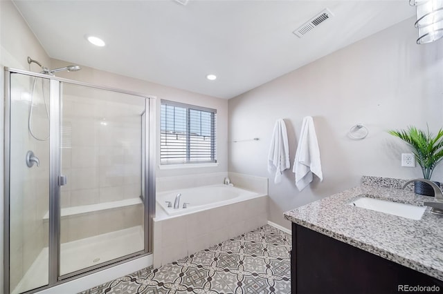 bathroom with plus walk in shower, vanity, and tile patterned floors