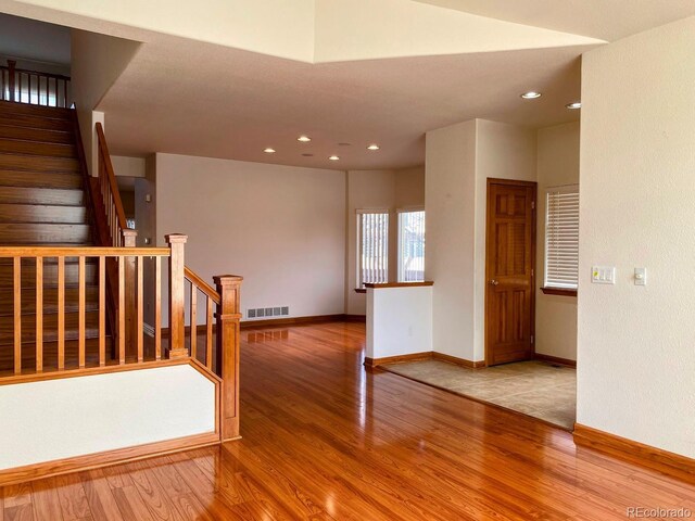 1022 Morning Dove Dr, Longmont, CO 80504 - empty room with wood finished floors, baseboards, stairway, and recessed lighting