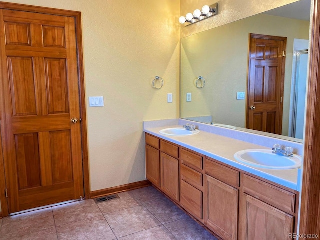 1022 Morning Dove Dr, Longmont, CO 80504 - full bathroom featuring double vanity, baseboards, tile patterned floors, and a textured wall