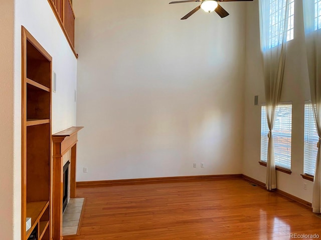 1022 Morning Dove Dr, Longmont, CO 80504 - unfurnished living room featuring ceiling fan, light wood-style floors, baseboards, and a fireplace with flush hearth