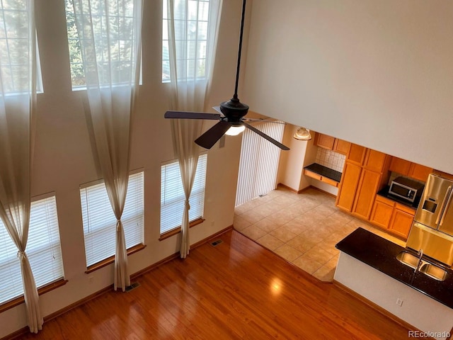 1022 Morning Dove Dr, Longmont, CO 80504 - unfurnished living room with light wood finished floors, a ceiling fan, healthy amount of natural light, and baseboards