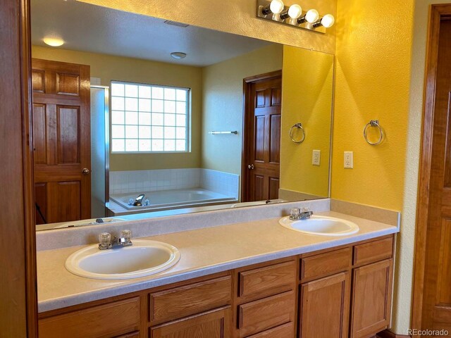 1022 Morning Dove Dr, Longmont, CO 80504 - bathroom featuring a textured wall, double vanity, and a bath