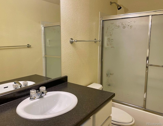 1022 Morning Dove Dr, Longmont, CO 80504 - bathroom featuring toilet, vanity, enclosed tub / shower combo, and a textured wall