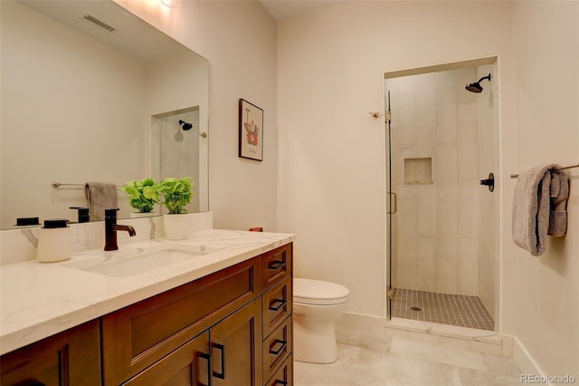 bathroom with vanity, toilet, and a shower with door