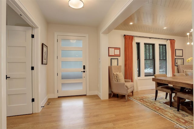 entryway with wooden ceiling, beam ceiling, and light hardwood / wood-style flooring