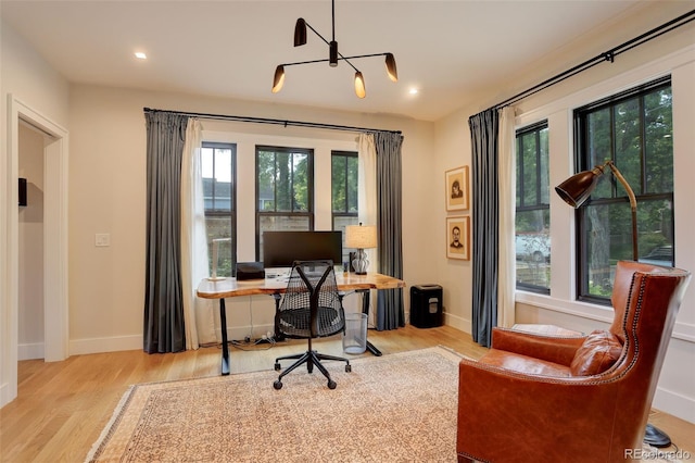 office with light wood-type flooring and a wealth of natural light