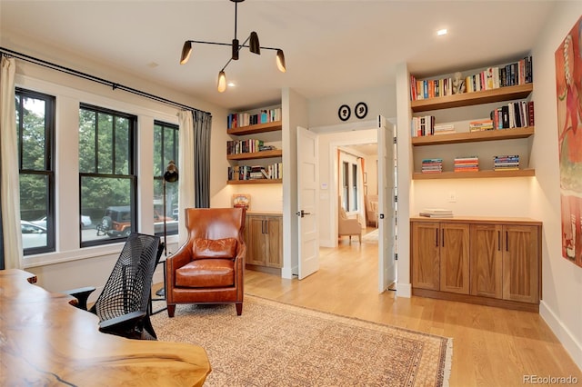 office area with built in features and light hardwood / wood-style floors