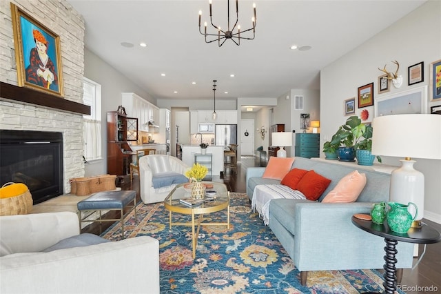 living area featuring a fireplace, recessed lighting, visible vents, wood finished floors, and a chandelier