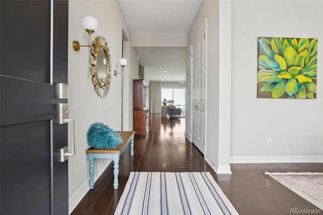 corridor featuring baseboards and wood finished floors