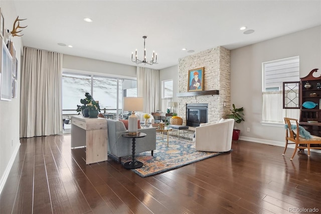 living room with a chandelier, a fireplace, dark wood finished floors, and baseboards