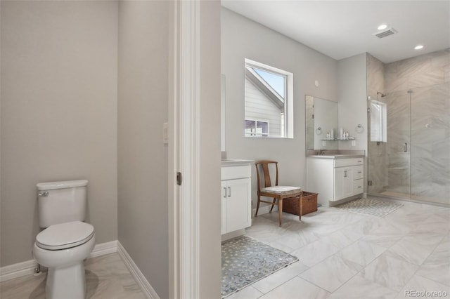 bathroom featuring toilet, vanity, visible vents, baseboards, and a stall shower