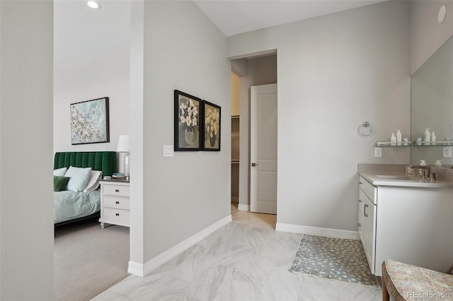 bathroom with connected bathroom, vanity, and baseboards