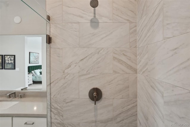 full bath featuring tiled shower and vanity