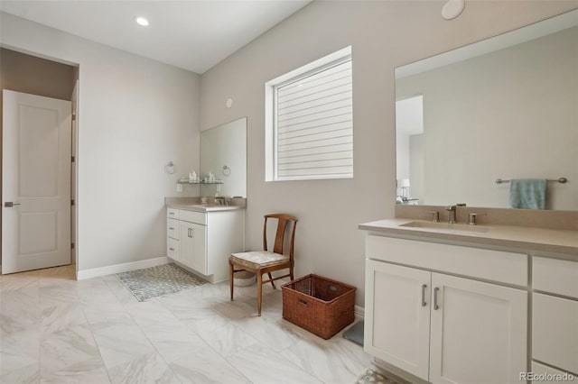 full bathroom featuring recessed lighting, two vanities, a sink, and baseboards