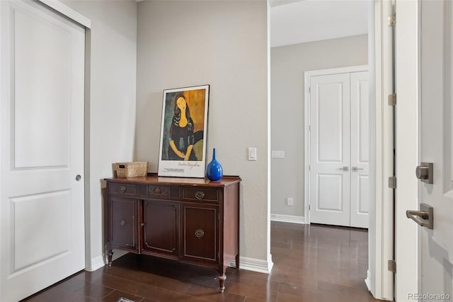 hallway featuring baseboards and dark wood-style flooring