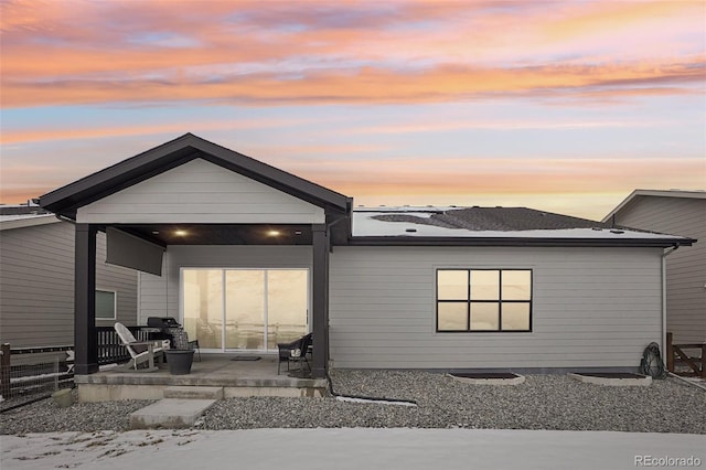 back of property at dusk with a patio