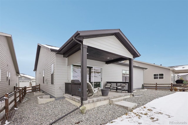 view of front facade featuring a garage, a patio area, and fence