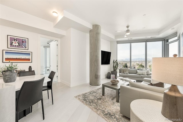 living room with light hardwood / wood-style floors and ceiling fan