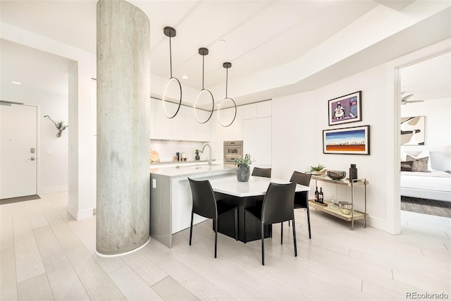 dining room featuring sink and light hardwood / wood-style flooring