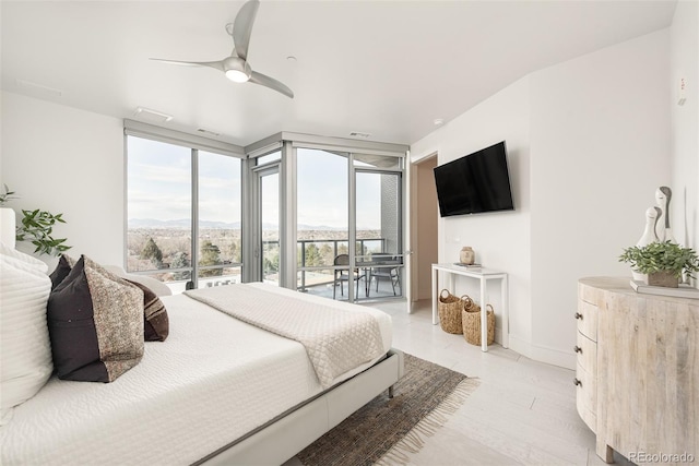 bedroom with light hardwood / wood-style floors, ceiling fan, a wall of windows, and access to exterior