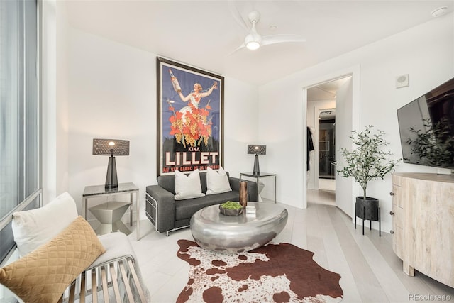 living room with light hardwood / wood-style flooring and ceiling fan