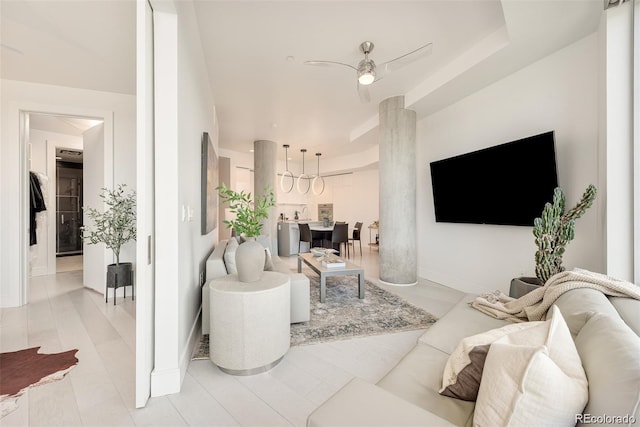 living room featuring decorative columns and ceiling fan