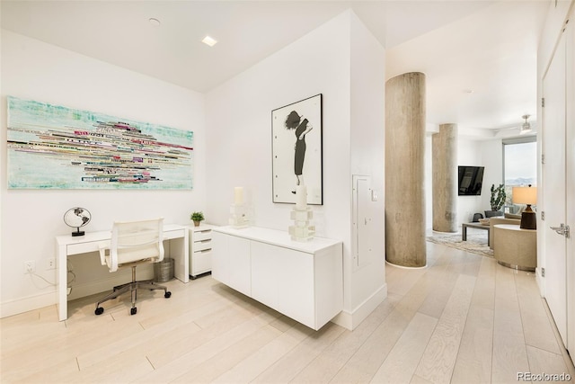 office space with light wood-type flooring, ceiling fan, and built in desk