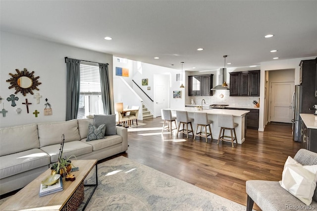 living room featuring sink and dark hardwood / wood-style floors