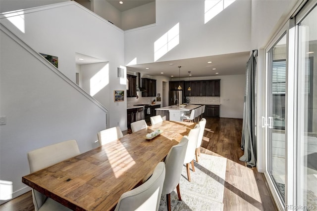 dining area featuring a high ceiling, dark hardwood / wood-style flooring, and sink