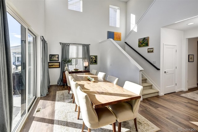 dining area with a high ceiling and wood-type flooring