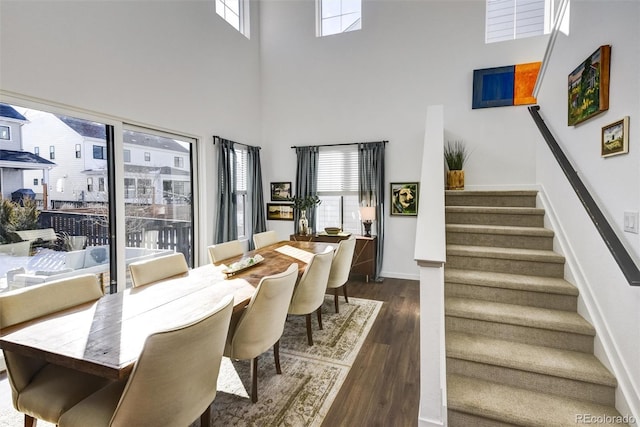 dining space featuring a high ceiling and dark wood-type flooring