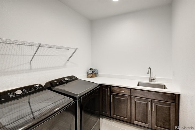 washroom with sink, cabinets, light tile patterned flooring, and washing machine and clothes dryer