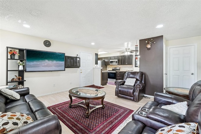 11941 Bellaire St Unit B, Thornton, CO 80233 - living area with light wood-type flooring, a textured ceiling, recessed lighting, ceiling fan, and bar